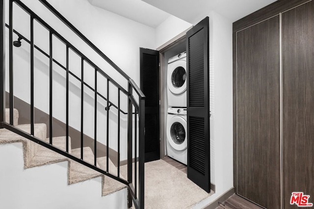 clothes washing area featuring stacked washing maching and dryer and light hardwood / wood-style floors