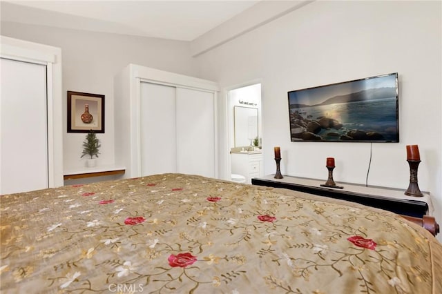 bedroom with ensuite bath and vaulted ceiling