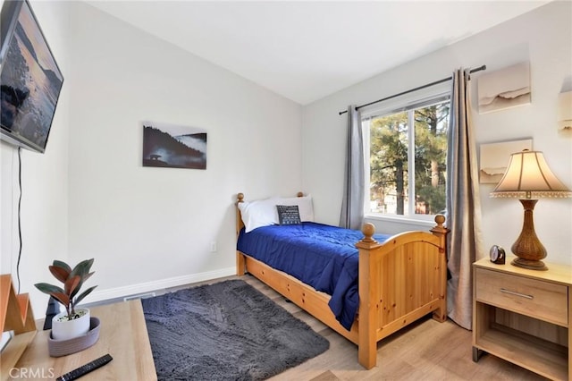 bedroom featuring vaulted ceiling and light hardwood / wood-style flooring