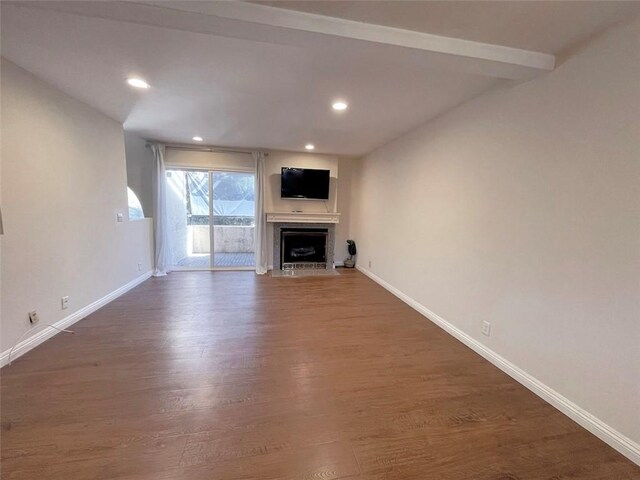 unfurnished living room with dark hardwood / wood-style flooring and beamed ceiling