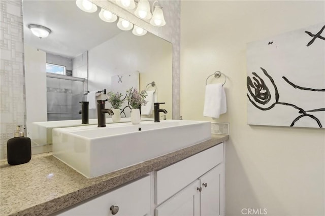 bathroom with a shower with door and vanity