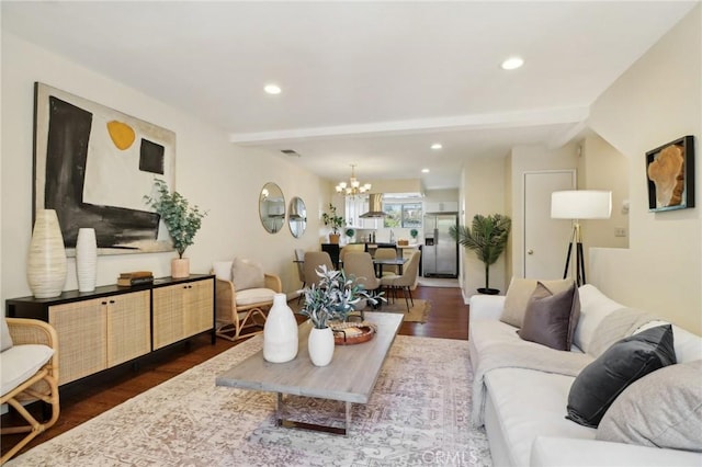 living room featuring an inviting chandelier, dark hardwood / wood-style flooring, and beamed ceiling