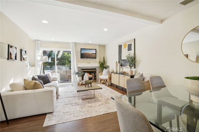 living room featuring dark wood-type flooring, a high end fireplace, and beamed ceiling