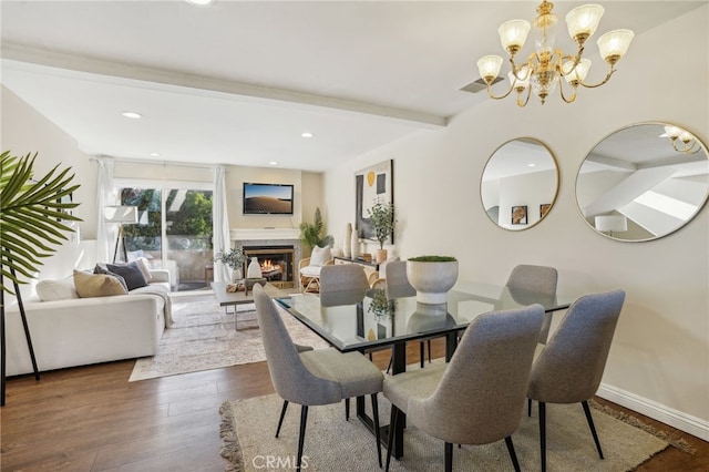 dining area with dark wood-type flooring, beam ceiling, and a chandelier