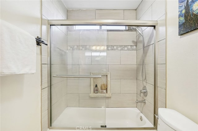 bathroom featuring toilet and enclosed tub / shower combo