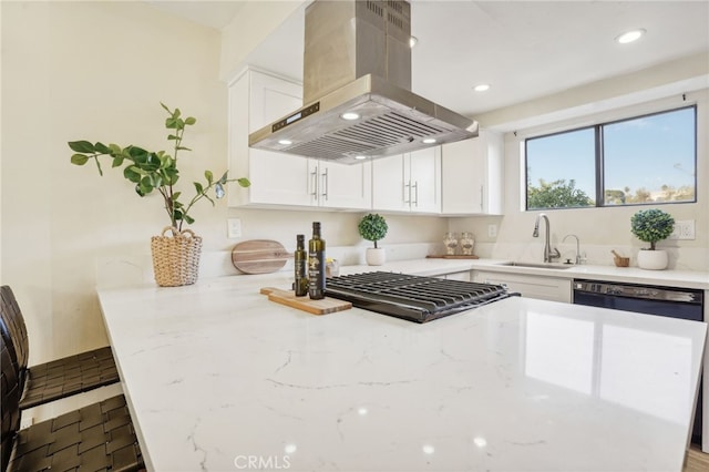 kitchen featuring range hood, light stone countertops, white cabinets, and sink