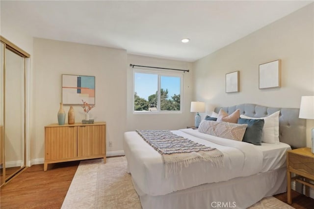 bedroom with light wood-type flooring and a closet