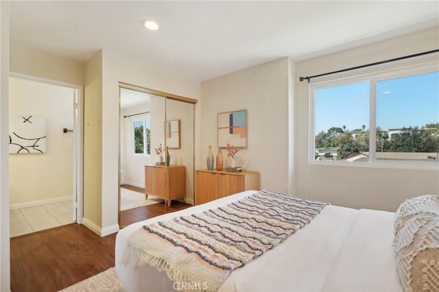 bedroom with dark wood-type flooring and a closet