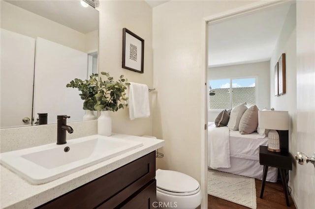 bathroom with hardwood / wood-style flooring, toilet, and vanity