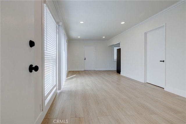 spare room with ornamental molding and light hardwood / wood-style floors