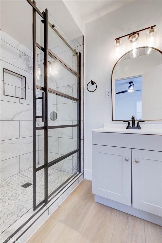 bathroom with vanity, wood-type flooring, and a shower with door