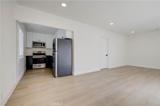 kitchen with white cabinetry, appliances with stainless steel finishes, and ornamental molding