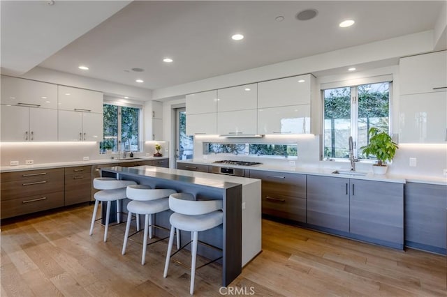 kitchen with a kitchen bar, white cabinetry, and a kitchen island