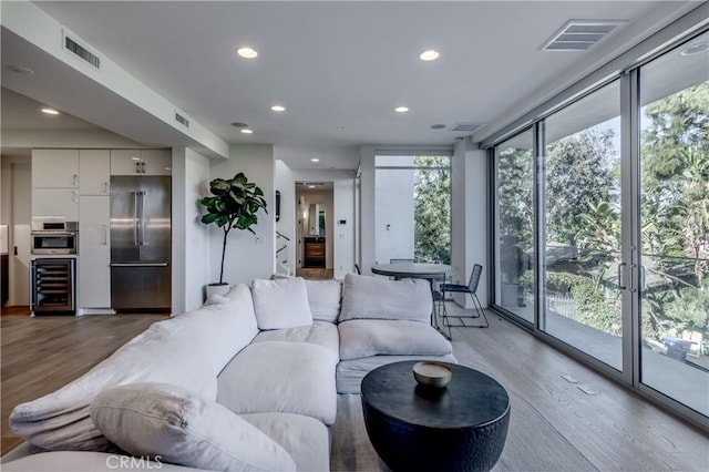 living room featuring hardwood / wood-style floors, beverage cooler, and expansive windows