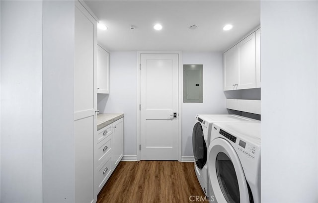 laundry room featuring cabinets, washing machine and dryer, dark wood-type flooring, and electric panel