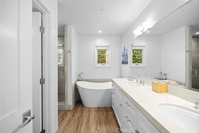 bathroom featuring independent shower and bath, hardwood / wood-style floors, and vanity