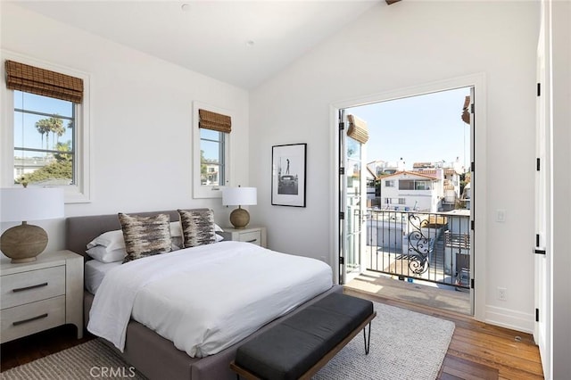 bedroom featuring dark hardwood / wood-style floors, access to outside, and vaulted ceiling