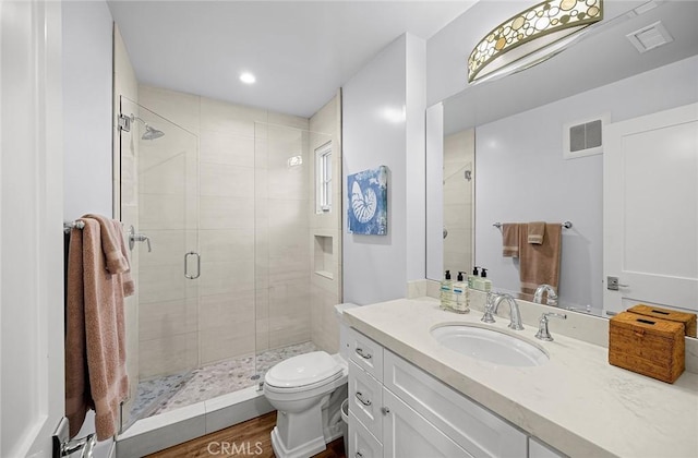 bathroom featuring vanity, toilet, hardwood / wood-style flooring, and walk in shower