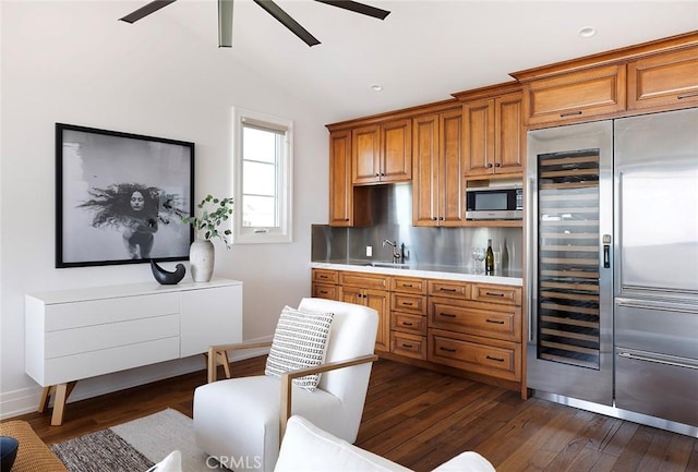 kitchen featuring stainless steel appliances, backsplash, dark wood-type flooring, lofted ceiling, and sink