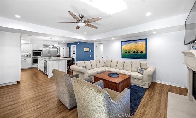 living room featuring ceiling fan and hardwood / wood-style flooring