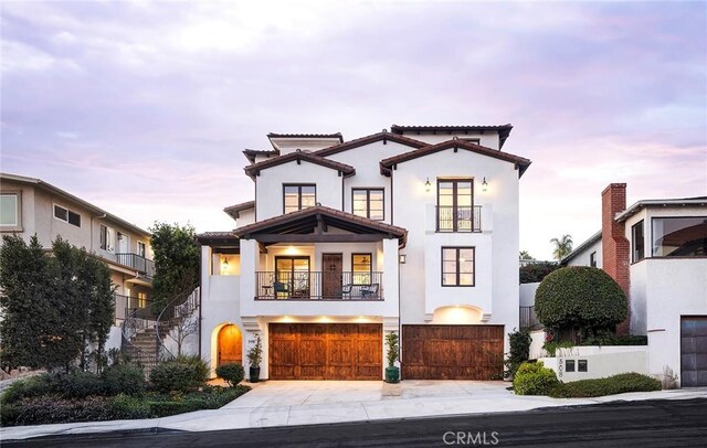 mediterranean / spanish-style home with a balcony and a garage