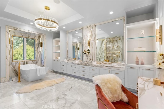 bathroom with vanity, independent shower and bath, an inviting chandelier, and a tray ceiling