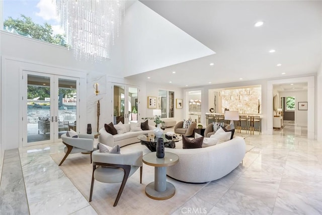 living room featuring french doors, a notable chandelier, and a high ceiling