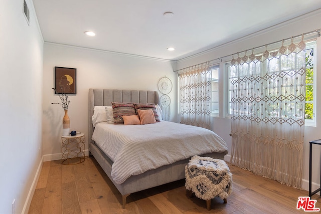 bedroom featuring hardwood / wood-style floors and ornamental molding