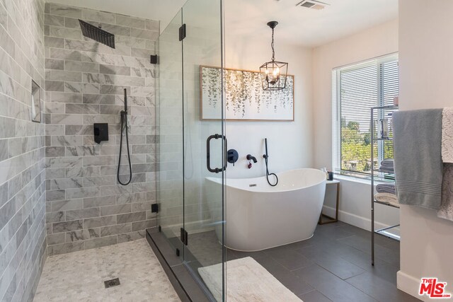 bathroom featuring an inviting chandelier, tile patterned flooring, and separate shower and tub