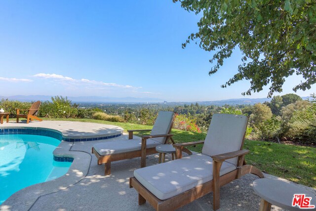 view of swimming pool with a patio area and a mountain view