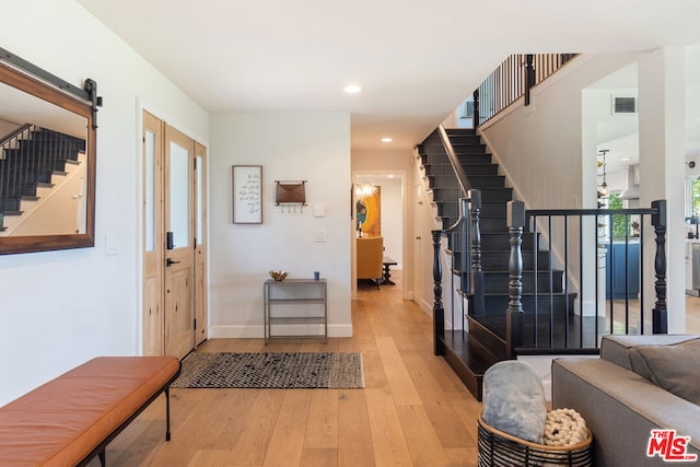 entryway featuring light hardwood / wood-style floors and a barn door