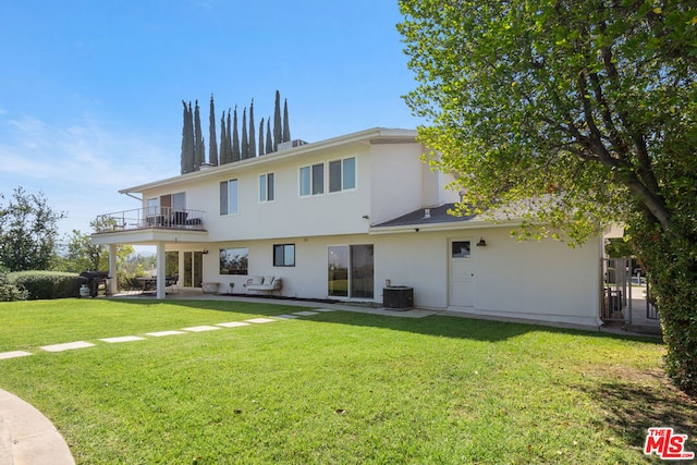 back of property featuring a patio area, a lawn, a balcony, and central air condition unit