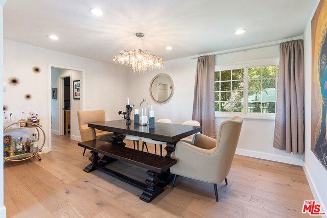 dining room featuring light hardwood / wood-style floors and a notable chandelier