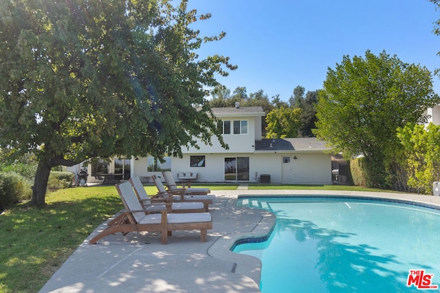 view of swimming pool with a yard and a patio