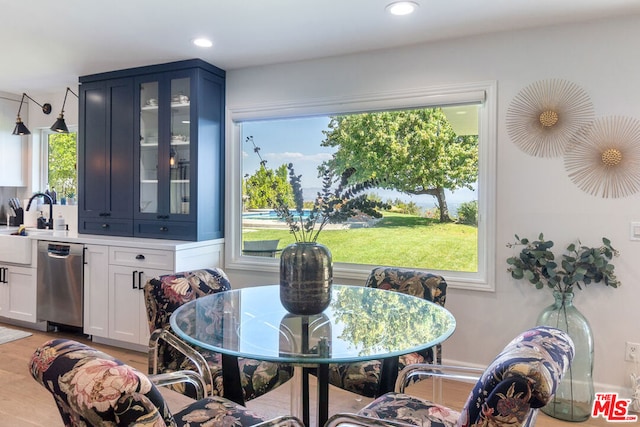 dining room with light wood-type flooring, plenty of natural light, and sink