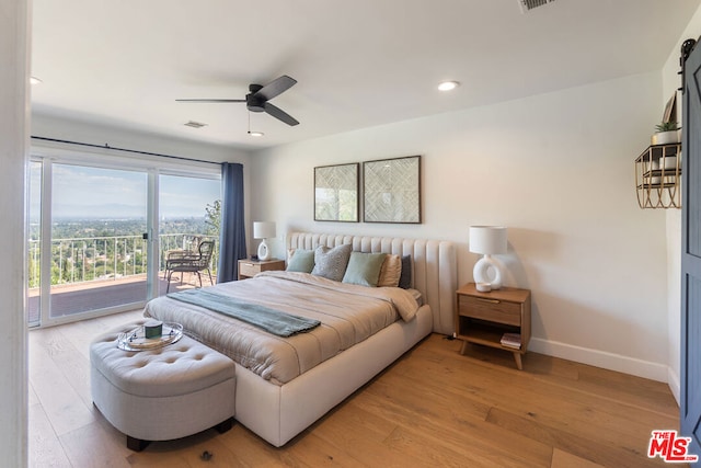 bedroom with access to outside, a barn door, ceiling fan, and light wood-type flooring