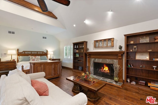 bedroom with a premium fireplace, dark hardwood / wood-style flooring, ceiling fan, and lofted ceiling with beams