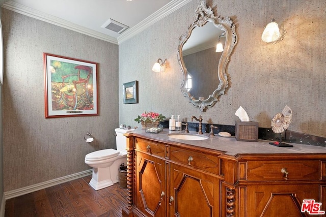 bathroom with hardwood / wood-style flooring, toilet, vanity, and crown molding