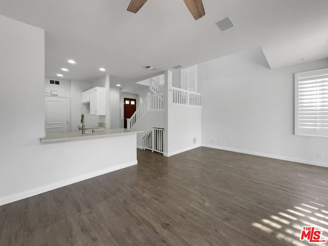 unfurnished living room featuring ceiling fan, dark hardwood / wood-style floors, and sink