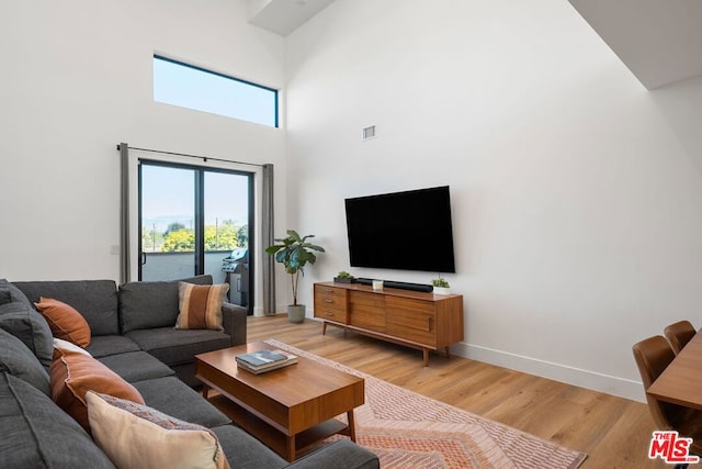 living room featuring a high ceiling and wood-type flooring