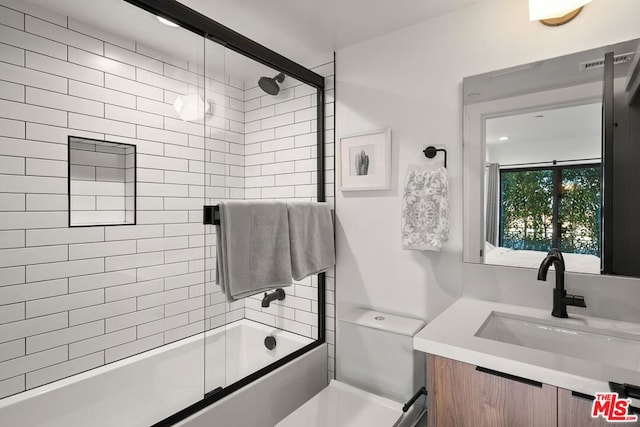 full bathroom featuring shower / bath combination with glass door, vanity, and toilet