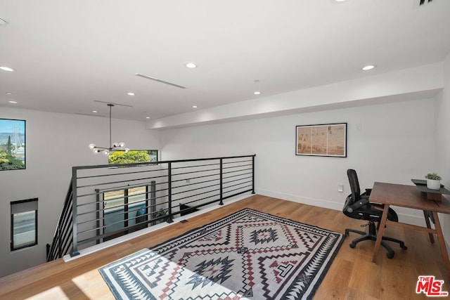 home office featuring a chandelier and light hardwood / wood-style flooring