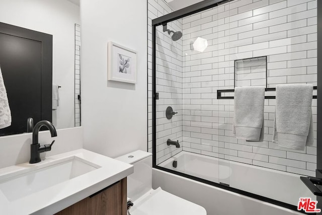 full bathroom with combined bath / shower with glass door, vanity, and toilet