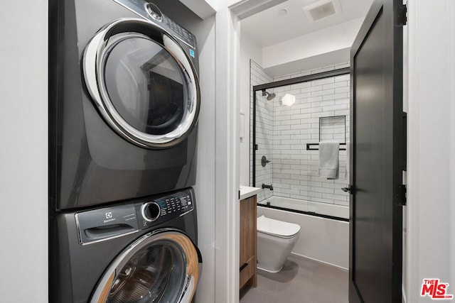 clothes washing area with stacked washing maching and dryer