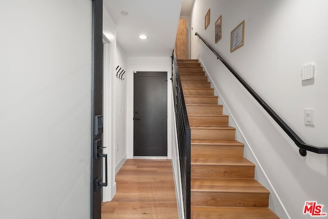 staircase with hardwood / wood-style floors