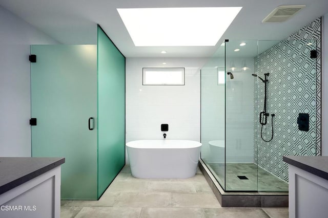 bathroom with plus walk in shower, vanity, and a skylight