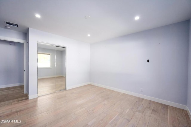 unfurnished bedroom featuring light hardwood / wood-style floors and a closet