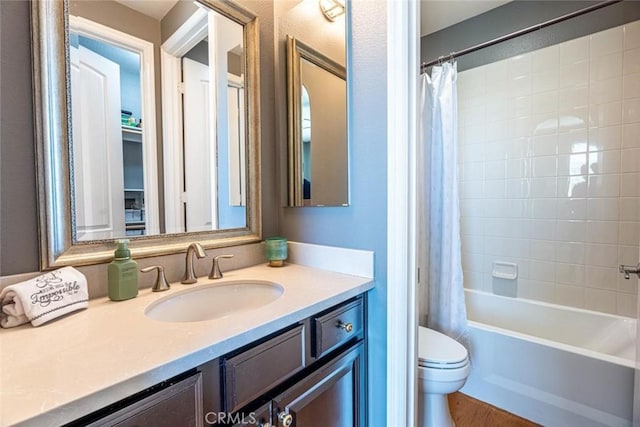 full bathroom with toilet, shower / bathtub combination with curtain, hardwood / wood-style flooring, and vanity