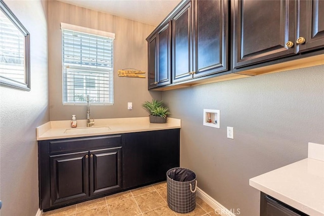 laundry room featuring cabinets, sink, light tile patterned floors, and hookup for a washing machine