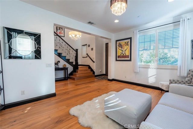 living room featuring wood-type flooring and a chandelier